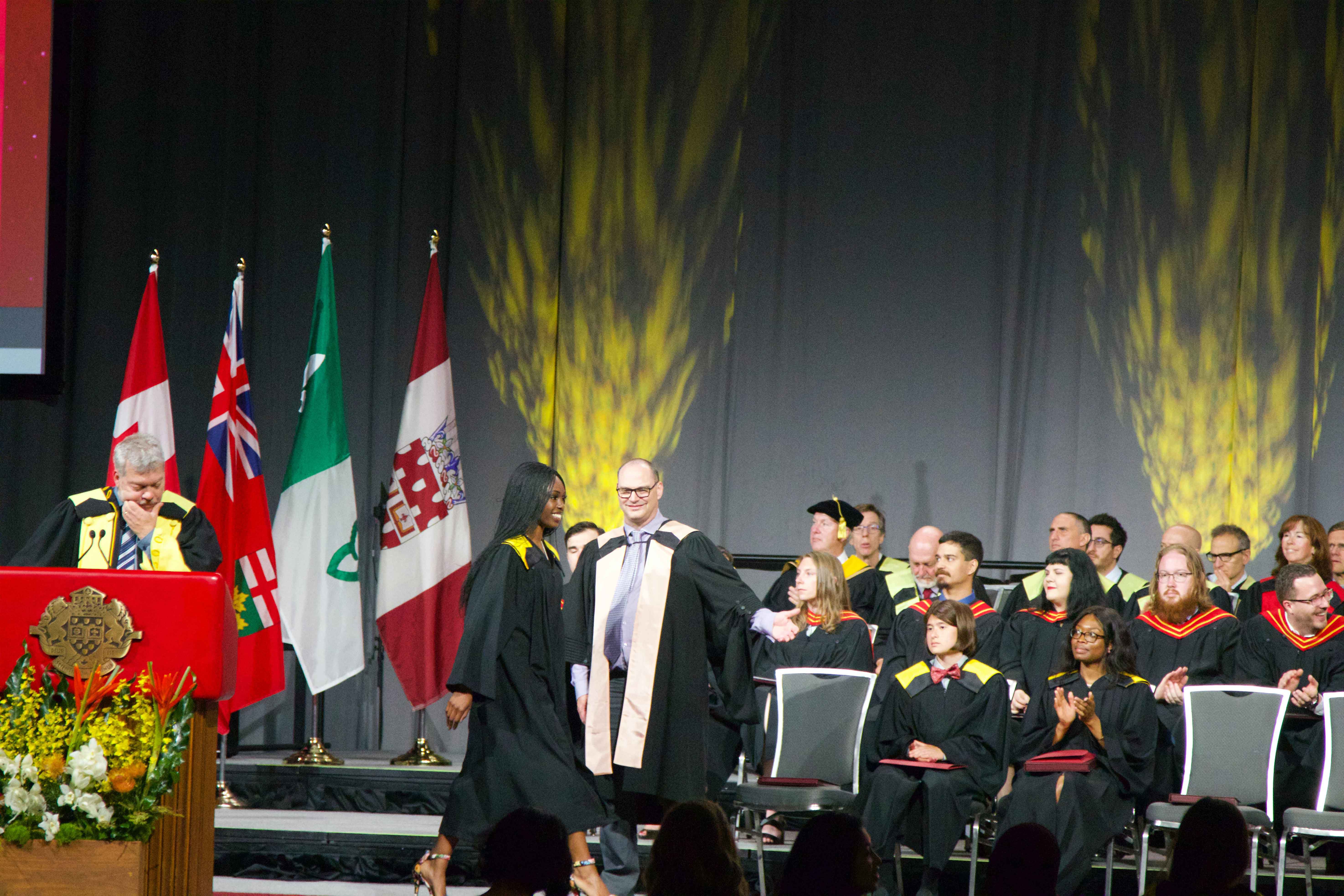students receive their diplomas on graduation day