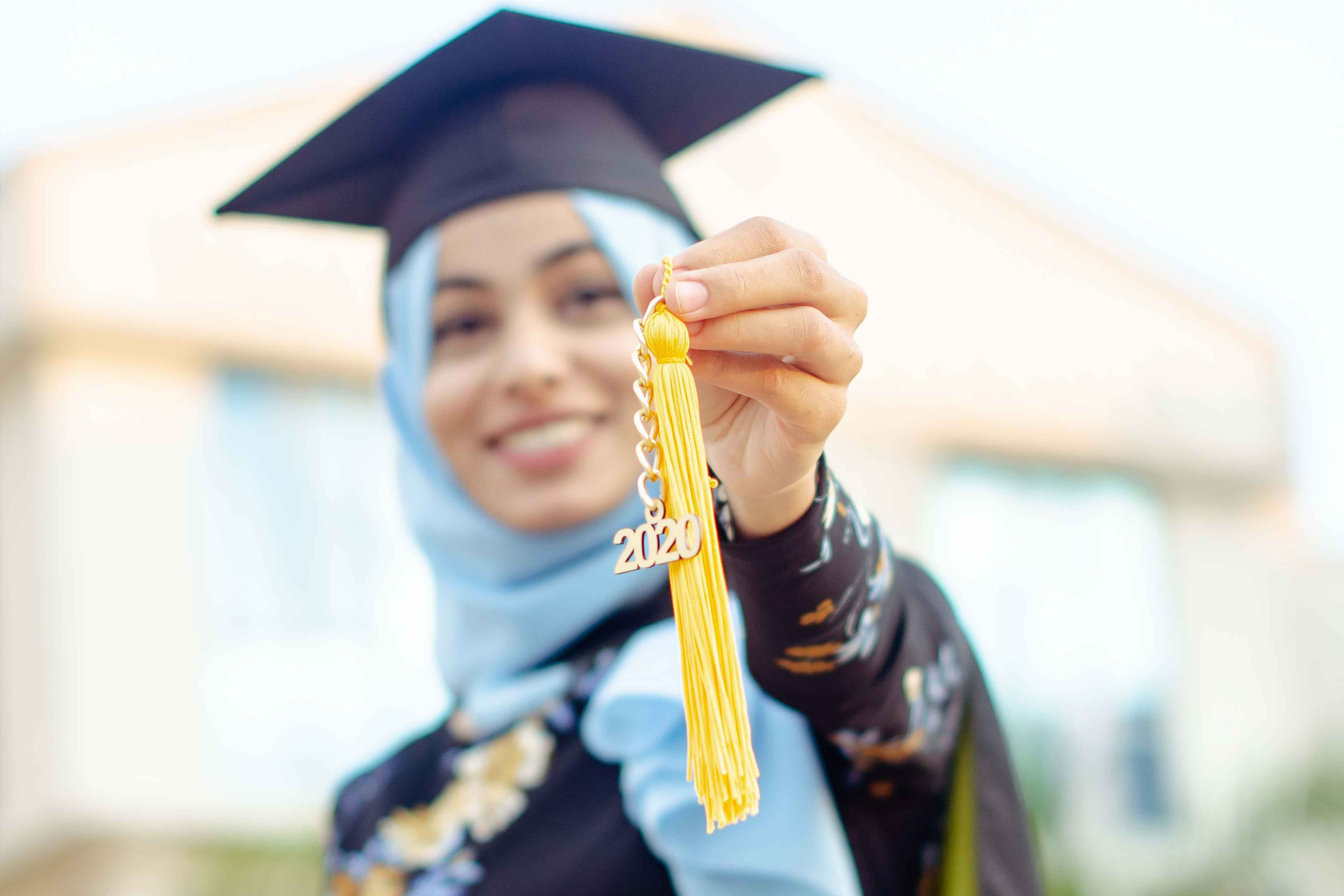 a student shows the emblem of her student hat with the words 2020
